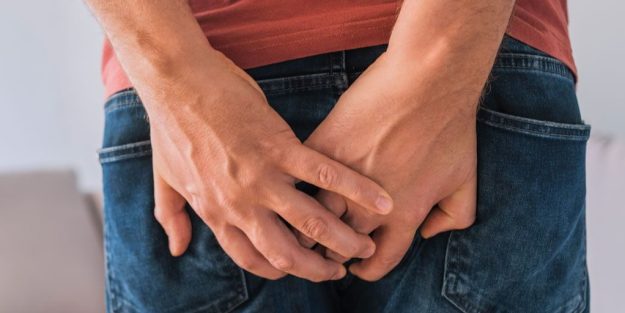 Άνδρας κρατά με τα χέρια την περιοχή του πρωκτού λόγω ενόχλησης